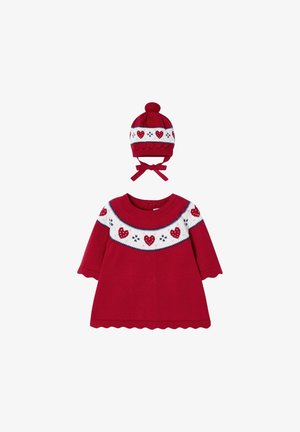 Rød babykjole med lange ærmer og hvid bærestykke med røde hjerter og snefnug, kombineret med matchende rød strikket hue med kvast og bindebånd.