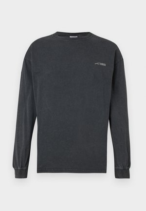 Garais pelēks kokvilnas krekls ar garām piedurknēm, ar apaļu kakla izgriezumu un mazu baltu logo kreisajā augšējā krūtīs. Gluda tekstūra.