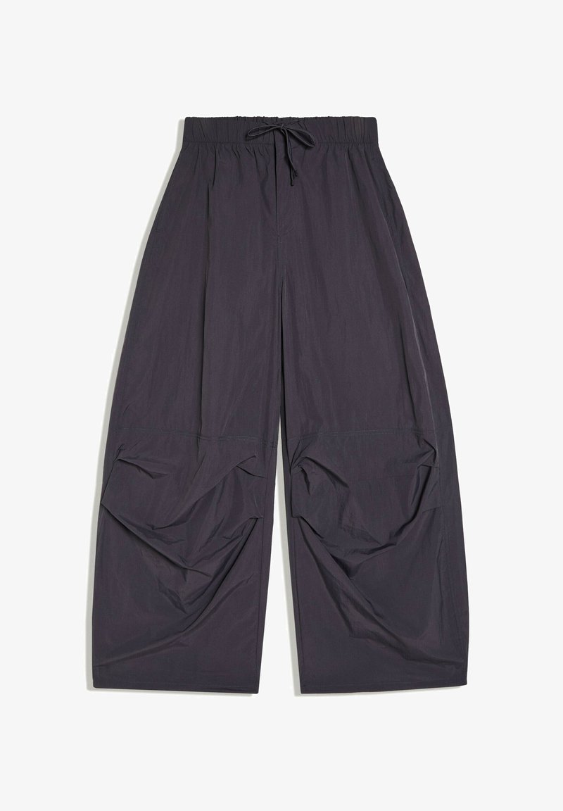 Pantalon large noir ample avec taille élastique et cordon, avec des détails de tissu froncés près des genoux.