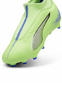 Scarpa da calcio verde con tomaia testurizzata, dettagli blu, design aerodinamico e tacchetti conici per la trazione. Caratterizzata da una vestibilità aderente con un alto collare.