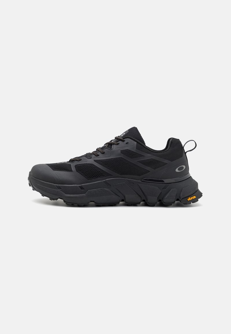Sapatos atléticos pretos com uma sola volumosa, parte superior em malha e sintético, acabamentos texturizados e marca Vibram na sola.