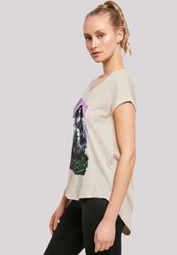 Cremfarbendes T-Shirt mit kurzen Ärmeln, das auf der Vorderseite einen mehrfarbigen Grafikdruck von Figuren und dem Text "Tied By Destiny" zeigt.
