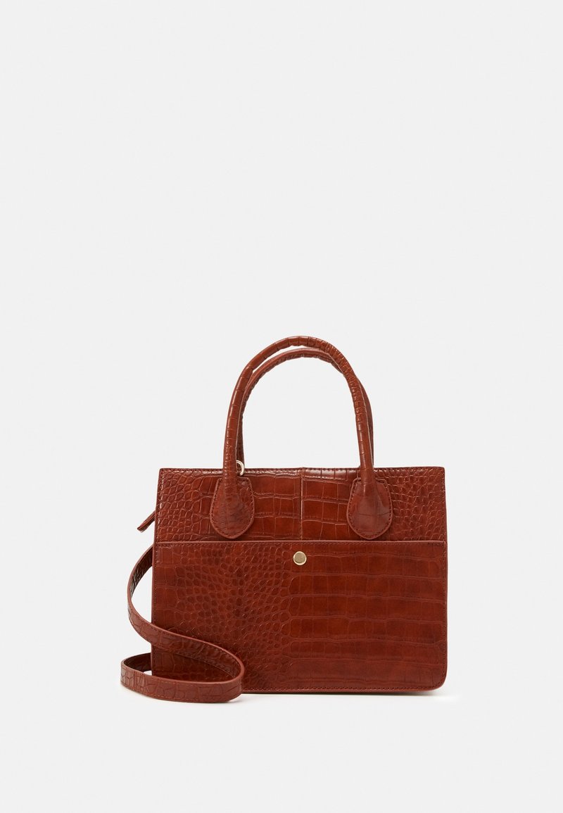 Sac à main en cuir marron à texture crocodile avec deux poignées supérieures, poche avant avec bouton-pression, et une longue bandoulière sur fond blanc.