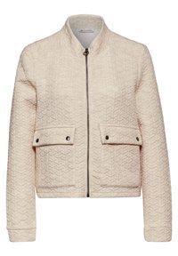 Veste matelassée beige clair avec un col haut, une fermeture éclair sur le devant, deux poches à rabat et une texture géométrique subtile sur le tissu.