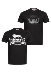 Camisetas de algodón negras con cuello redondo, una con un gráfico de león blanco y el texto "Lonsdale London", y la otra con un gráfico plateado.