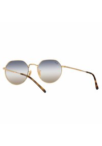 Gafas de sol redondas con marco de metal dorado, lentes gris degradado y acentos de carey en las patillas. Diseño delgado y elegante.