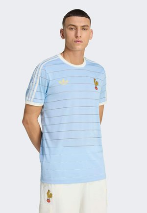 Hellblaues Sporttrikot mit horizontalen Streifen, weißem Kragen und Ärmeln, goldenem Logo auf der Brust und einem Hahn-Emblem.