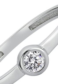 Bague en argent avec une pierre précieuse ronde et transparente sertie dans un anneau lisse avec un accent texturé, présentant un design moderne et minimaliste.