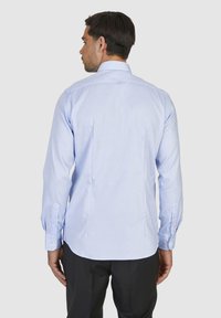Lichtblauw langemouwshirt gemaakt van gladde stof, met een puntige kraag en knoopmanchetten, met een rechte rugontwerp.