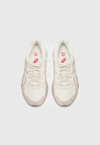 Sportiga sneakers med ovandel i mesh och mocka, huvudsakligen i krämfärg med rosa detaljer, Utrustade med snörning och vadderad krage för komfort.