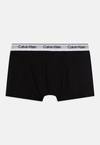 Mustad puuvillased bokserid mustas värvuses, valge elastse vöökoha ja Calvin Kleini logoga. Ees on liibuv ja sile tekstuur, ilma mustriteta.
