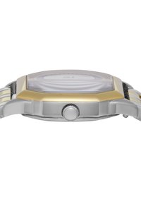 Silver and gold-tone octagonal watch with a clear face, textured dial, and side push-button for adjustment; stainless steel bracelet.