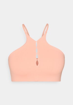 Bralette color pesca realizzato in un tessuto morbido ed elastico. Presenta spalline sottili e un design aperto sulla schiena con un dettaglio a buco chiave.