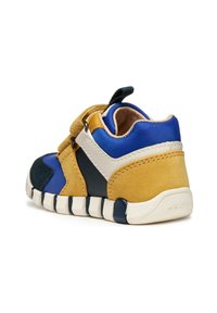 Zapatillas multicolor para niños pequeños con gamuza amarilla, textil azul, acentos de cuero blanco y una suela de goma flexible con patrón de tracción.