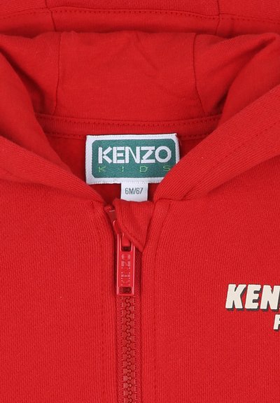 Felpa rossa con zip realizzata in tessuto morbido. Presenta un cappuccio, una cerniera frontale e il logo "KENZO KIDS" in bianco sul lato sinistro.