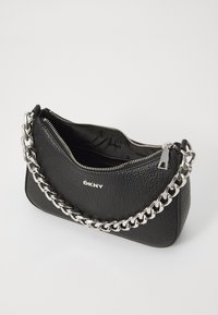 Black leather handbag with a textured finish and a silver chain strap. Features a zip closure and branded logo on the front.