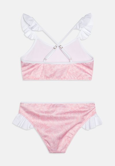 Rosafärgad bikini med blommönster och vita volangband. Toppens design har korskorsning med metallisk hårdvara; botten har matchande volanger.
