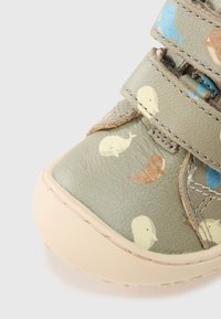 Παιδικό παπούτσι χακί πράσινο με σχέδια φαλαινών σε μπλε, καφέ και κίτρινο, με λαστιχένια σόλα και ιμάντες βέλκρο για κλείσιμο.