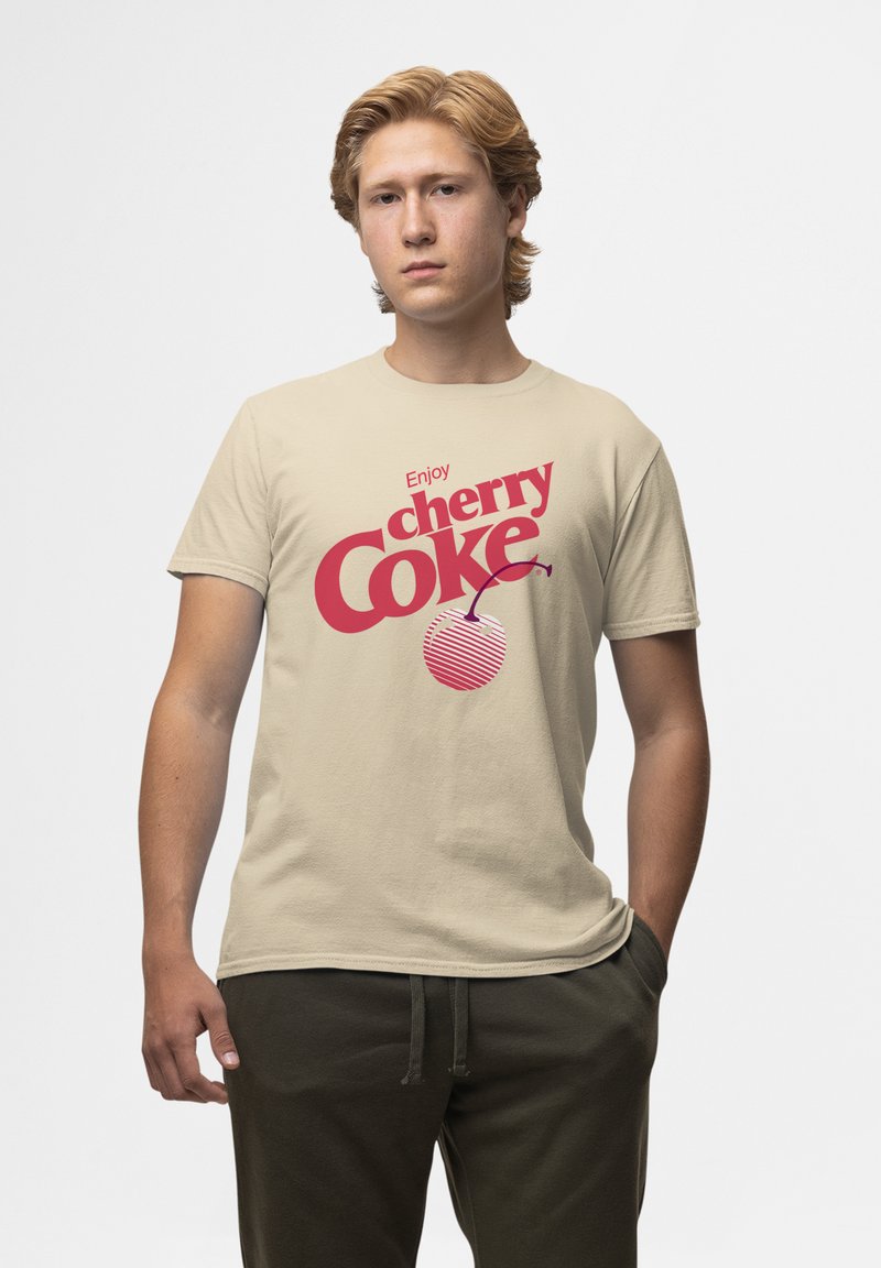 Beige katoenen t-shirt met gedurfde rode tekst "Geniet van cherry Coke" en een grafische kersenlogo met gestreepte details. Relaxed fit, ronde hals.