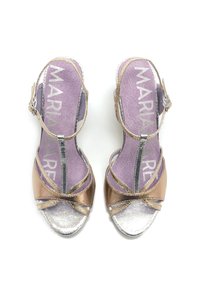 Sandales ouvertes avec des sangles en bronze métallisé et en argent, présentant un design en croix, une sangle de cheville ajustable et une semelle intérieure rembourrée violette.
