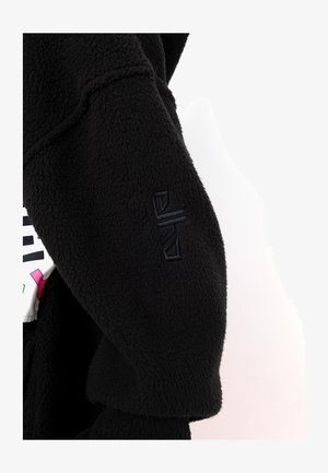 Schwarze Fleecejacke aus strukturiertem Stoff mit einem dezenten gestickten Logo auf dem Ärmel und einem kontrastierenden grafischen Design auf dem Körper.
