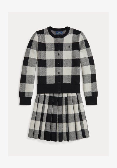 Črno-bela karirasta obleka z dolgimi rokavi, naborki na krilu, gumbi spredaj in rebrastimi manšetami. Narejena iz mehke pletenine.