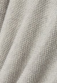 Lichtgrijze gebreide stof met een gestructureerd patroon, met een gladde, zachte oppervlakte en subtiele variaties in tint. Ideaal voor kleding of stoffering.