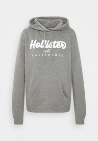 Felpa grigia con cappuccio e tasca a marsupio, caratterizzata da testo bianco "Hollister" con "California" sottostante, realizzata in morbido cotone.