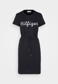 Czarna, codzienna sukienka z krótkimi rękawami, dopasowaną talią i sznurkiem. Na przodzie znajduje się błyszczące logo "Hilfiger".