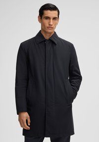 Schwarzer, langer Mantel mit strukturiertem Kragen, vorderem Knopfverschluss und seitlichen Taschen; aus glattem Material gefertigt, das eine elegante Silhouette bietet.