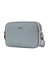 Lyseblå rektangulær crossbody-taske lavet af tekstureret syntetisk læder, med en guldfarvet logo, lynlås og aftagelig skulderrem.