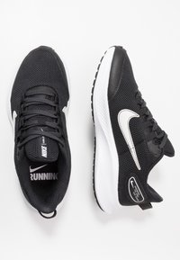 Schwarze Nike-Laufschuhe mit einem Obermaterial aus Mesh, weißen Akzenten, runden Schnürsenkeln und einer strukturierten Sohle, die für Komfort und Leistung entwickelt wurden.