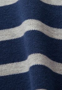 Gros plan d’un tissu tricoté avec de larges rayures horizontales bleu marine et gris clair.