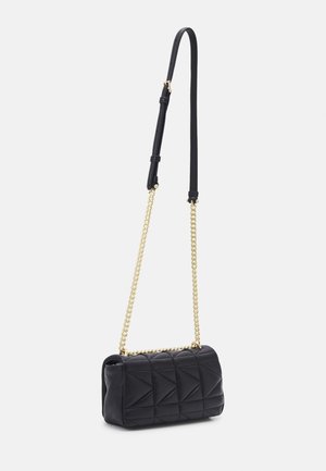 Sac à main matelassé noir avec bandoulière réglable en cuir et chaîne dorée sur fond blanc.
