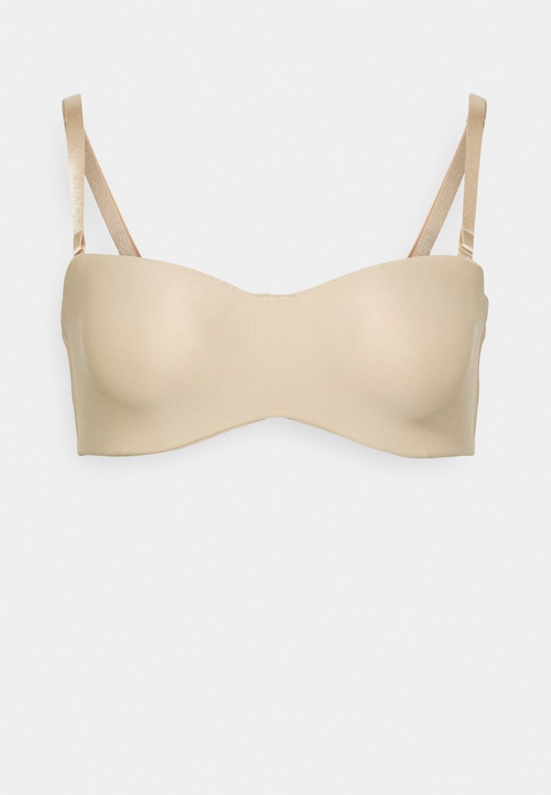 Lys beige stroppeløs bh med glatt stoff, formede kopper og tynne satengstropper. Minimalistisk design uten tilleggsmønstre eller tilbehør.