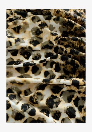 Tissu imprimé léopard avec des taches noires irrégulières sur un fond beige et marron, avec une texture lisse et un tombé fluide.