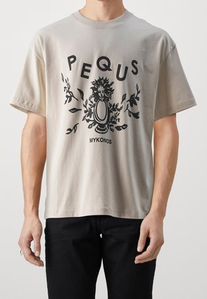 Beżowy T-shirt z czarną grafiką przedstawiającą stylizowany wazon z twarzą słońca otoczony liśćmi, z napisem "PEQUS" powyżej i "MYKONOS" poniżej.
