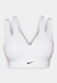 Bijela sportska grudnjak s okruglim izrezom, debelim trakama i dizajnom leđa u obliku križa. Nike logo u crnoj boji na središnjem prednjem dijelu. Glatka tekstura.