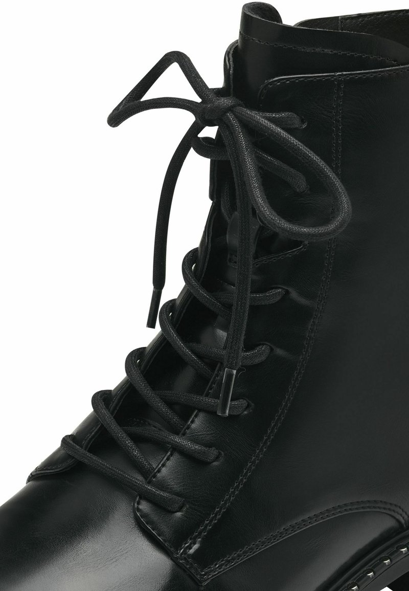Botte en cuir noir avec des lacets, un bout arrondi, une finition lisse et des œillets pour les lacets. Couture solide avec un léger talon.