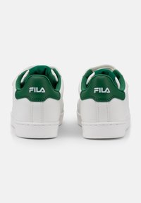 Sneakers bianchi con dettagli verdi, tallone in pelle testurizzata e collare imbottito. Presentano il logo sul tallone e una suola in gomma.