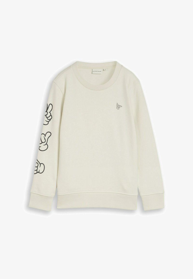 Sweat-shirt à manches longues couleur crème avec col rond, petit motif de main sur la poitrine et trois motifs plus grands de mains noires le long de la manche gauche.