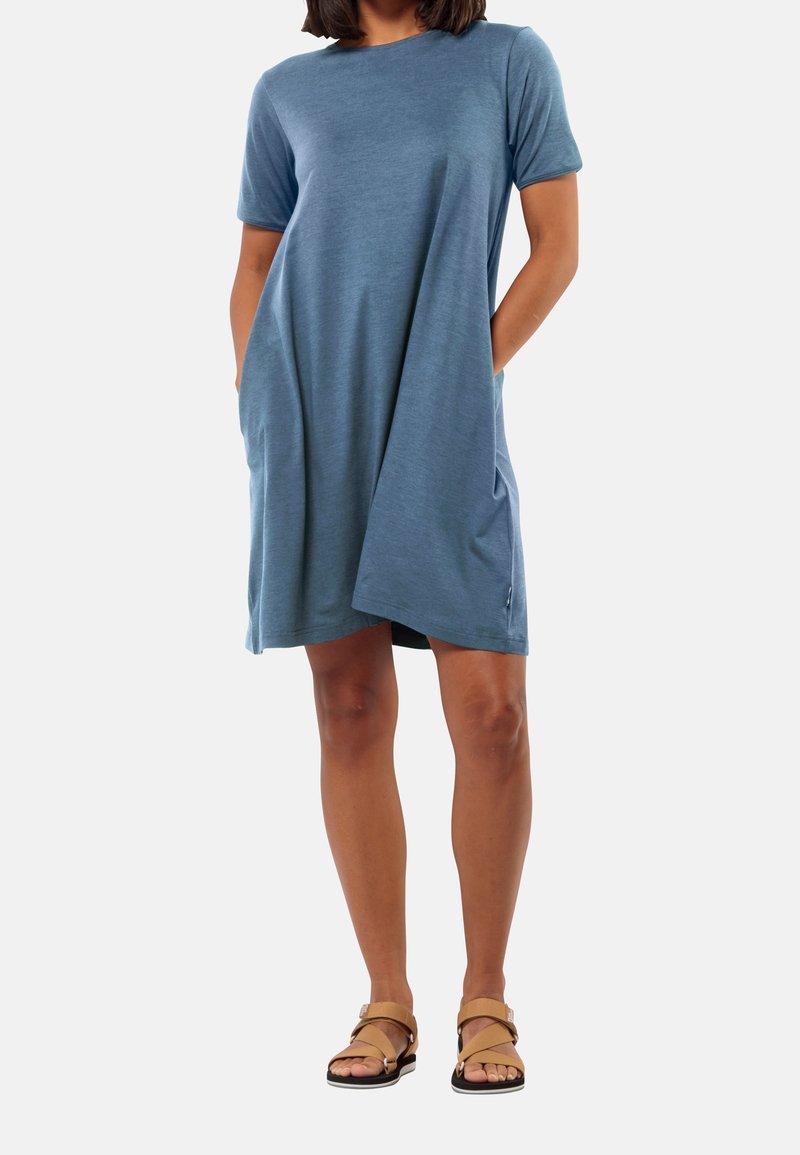 Robe bleue à manches courtes en tissu doux, avec une coupe ample, des poches latérales et un col rond, associée à des sandales marron.