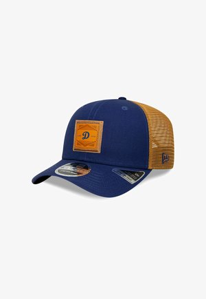 Casquette bleu marine avec un dos en mesh beige. Présente un patch carré marron avec un logo en relief. Visière arrondie et fermeture à pression réglable.