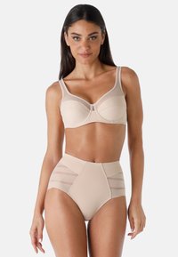 Reggiseno nudo con un design strutturato e spalline trasparenti, abbinato a slip a vita alta con pannelli in rete laterali e una texture morbida.