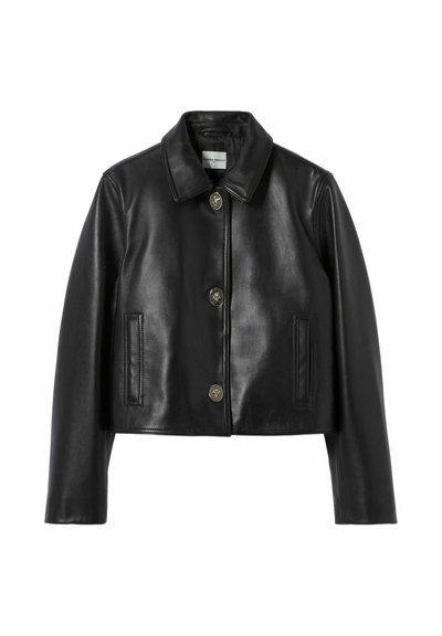 Chaqueta corta de cuero negro con cuello puntiagudo, tres botones delanteros y dos bolsillos verticales ribeteados a cada lado.