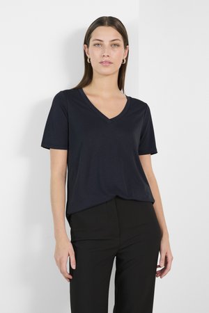 Navy V-neck t-shirt with short sleeves, made of soft fabric. Features a relaxed fit and minimal stitching, worn with black pants.