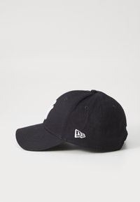 Black baseball cap with a curved visor, featuring white embroidery on the front and a small white logo on the side. Cotton material.