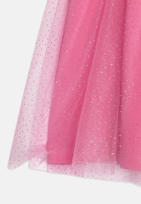 Ροζ τούλινο ύφασμα με ασημένιες λαμπερές λεπτομέρειες. Διαθέτει πολυεπίπεδο σχέδιο με υφή, δημιουργώντας μια απαλή, παραμυθένια εμφάνιση.