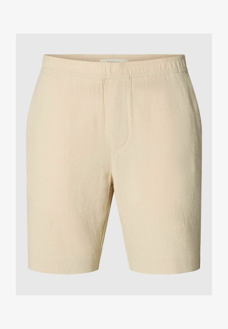 Short beige texturé jusqu'au genou avec une taille élastique et des détails subtils de couture devant.
