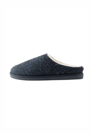 Chausson gris foncé texturé à enfiler avec doublure en polaire blanche et semelle noire plate, vu de profil sur un fond blanc.